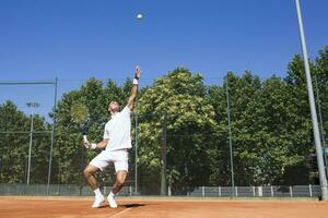 Tennis player serving a tennis ball during a tennis match photo