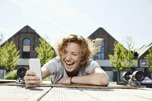 Happy young woman using smartphone in urban surrounding photo