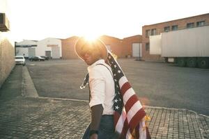 Laughing young man with American flag at backlight photo