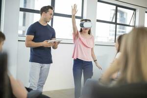 Teacher with tablet student wearing VR glasses in class photo