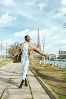 Francia, París, contento mujer caminando a el orilla con el eiffel torre en el antecedentes foto