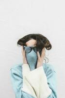Young woman covering her face with turtle neck photo