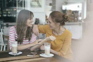 Two girlfriends meeting in a coffee shop, talking photo