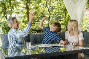 Happy father and son high fiving after winning a game on terrace photo