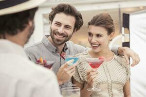 Couple and friend socializing on a cocktail party photo