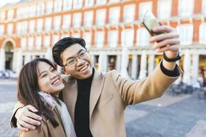 España, Madrid, contento joven Pareja tomando un selfie en el ciudad foto