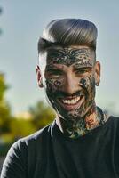 retrato de sonriente tatuado joven hombre al aire libre foto