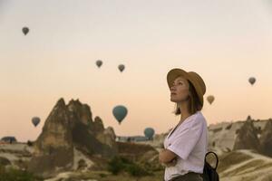 joven mujer y caliente aire globos, goreme, capadocia, Turquía foto