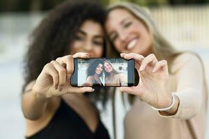 dos amigos tomando selfie con célula teléfono, de cerca foto