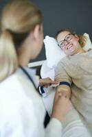 Female doctor taking a blood sample from patient in medical practice photo