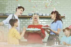 Mother and sons celebrating grandmother's bithday in their kitchen photo