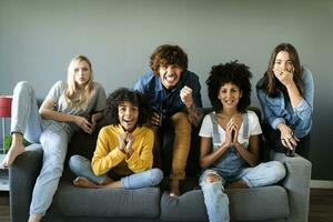 nervioso amigos sentado en sofá acecho televisión foto