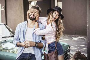 Happy couple at a convertible car outside house photo