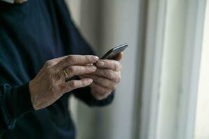 Close-up of senior man using cell phone at home photo