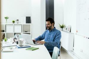 Man using laptop in office photo