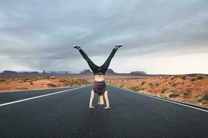 USA, Utah, Young man dong handstand on road to Monument Valley photo