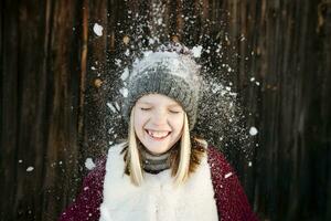 Snow falling on happy girl wearing woolly hat photo