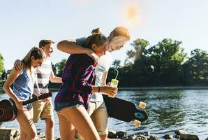 Group of happy friends walking at the riverside photo