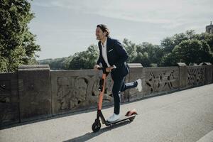 Businessman with e-scooter on a bridge photo