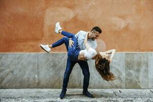 Carefree couple in love in front of a wall outdoors photo