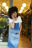 Happy woman on cell phone standing in entrance door of a store photo