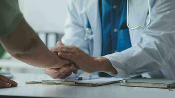 Female doctor in white coat holding hand of senior patient, giving help, comfort, psychological support, empathy at appointment. Elderly medic care, geriatric healthcare concept. Close up video