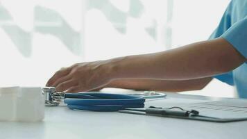 Doctor and patient sitting and talking at medical examination at hospital office, close-up. Therapist filling up medication history records. Medicine and healthcare concept. video