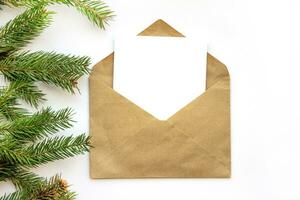 Minimalistic postcard layout with spruce branch. Kraft envelope, flat lay, top view close up. photo