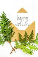 Birthday greeting card. Craft envelope on a white background. A cypress branch is a symbol of longevity. photo