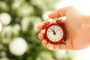 Young hands christmas alarm clock Photo in old color image style