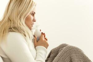 Ill woman sitting on her bed while holding her hair photo