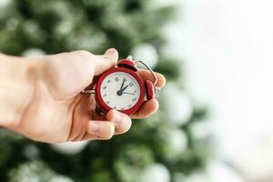 Young woman hands christmas alarm clock Photo in old color image style