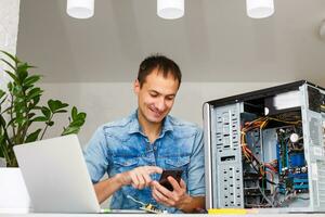 Man using laptop to check servers in data center photo