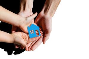 people, charity, family and home concept - close up of woman and girl holding paper house cutout in cupped hands photo