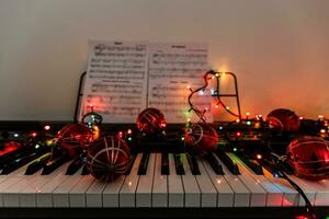 A piano with christmas lights and tree photo