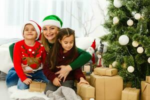 madre gasto hora con hijas cerca Navidad árbol foto