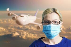 woman in protective mask on the background of the plane. Canceled air services due to a coronavirus epidemic photo
