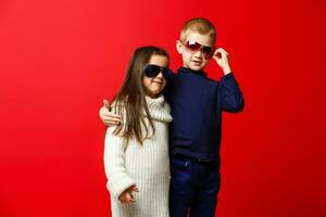 pequeño niña y chico en Gafas de sol foto