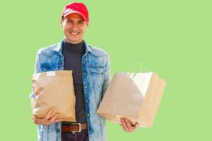 Delivery man in mask and gloves bring fresh food to customer's home. Stay home. Online shopping concept. green background photo