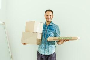 delivery man holding pile of cardboard boxes in front with copy space photo