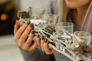 Festive Christmas and New Year table setting in scandinavian style with rustic handmade details in natural and white tones. Dining place decorated with pine cones, branches and candles photo