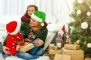 madre gasto hora con hijas cerca Navidad árbol foto