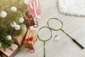 gifts and a tennis racket lie near a Christmas tree photo