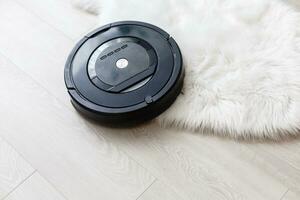 Robotic vacuum cleaner on parquet - technology housework photo