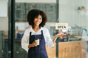 Startup successful small business owner sme African woman stand with tablet  in cafe restaurant. woman barista cafe owner. photo