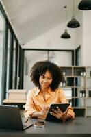 Business woman using tablet and laptop for doing math finance on an office desk, tax, report, accounting, statistics, and analytical research concept in office photo