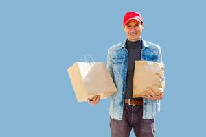 entrega hombre en máscara y guantes traer Fresco comida a clientes hogar. permanecer hogar. en línea compras concepto. azul antecedentes foto