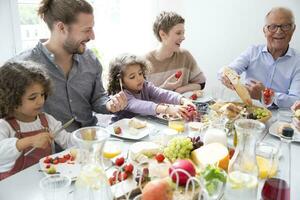 contento extendido familia teniendo almuerzo a hogar foto