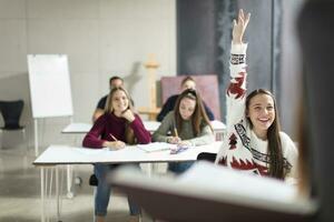 sonriente Adolescente niña levantamiento mano en clase foto