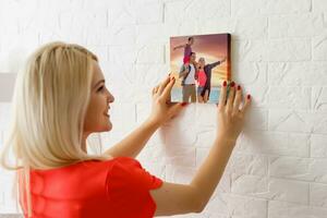 Canvas prints. A woman holding photo canvas. photo printed on glossy synthetic canvas and stretched on wooden stretcher bar
